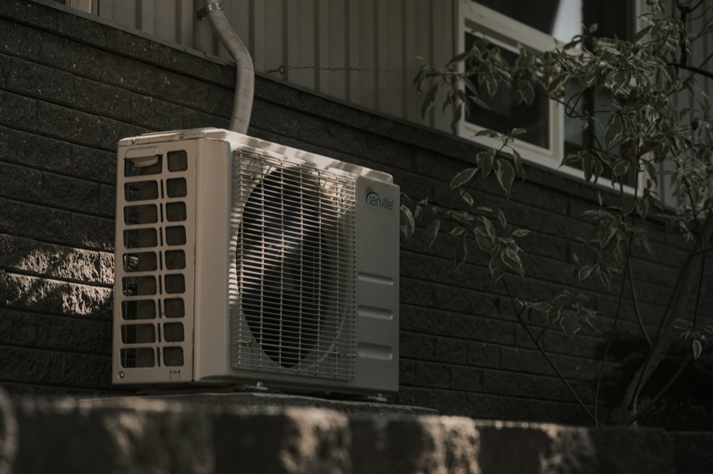 Central air conditioning condenser unit installed outside a shoreline home