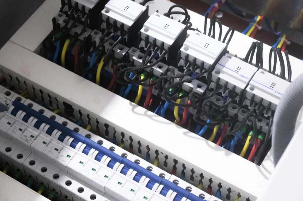 Licensed electrician installing a breaker panel in a Grand Bend area home